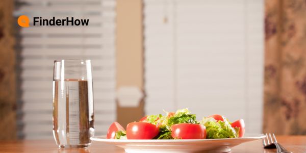 glass of water and a colorful salad