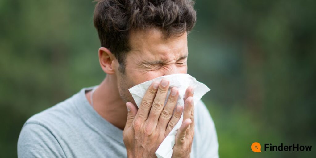 Close-up of a person sneezing with irritated eyes due to airborne allergens